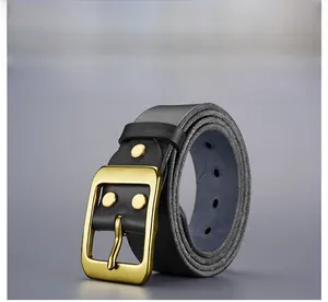 Détail de ceinture en cuir noir vintage avec boucle dorée brossée et rivets décoratifs