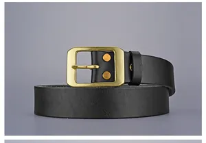 Détail d'une ceinture vintage en cuir noir avec boucle ardillon en laiton doré mat