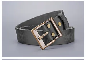 Close-up of vintage bronze buckle and textured genuine leather belt with rivet detail