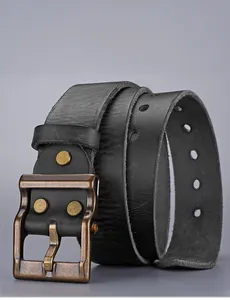 Detail of vintage black leather belt with antique bronze pin buckle and textured surface