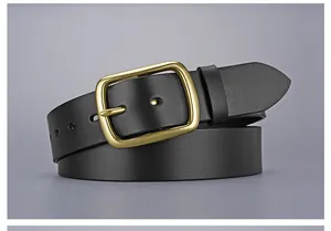 Detail of premium black leather belt showing a vintage golden pin buckle and texture