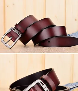 Detail van donker roodbruine lederen riem met mat zilveren gesp op houten achtergrond