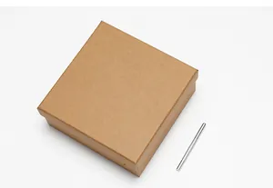 Detail van vierkante kraftpapier geschenkdoos met een gekartelde metalen riempons