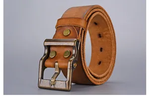 Macro shot of vintage bronze buckle and genuine leather texture on men's work belt