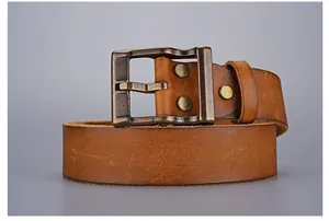 Detail of vintage brown leather belt with rustic copper buckle and metallic rivets