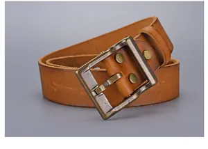 Detail of vintage brown leather belt with distressed brass buckle and natural texture