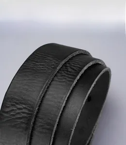 Detail of genuine top grain leather belt showing natural texture and solid brass buckle