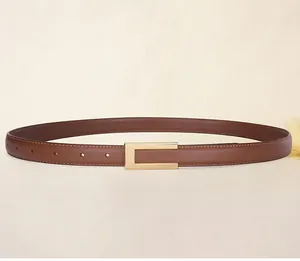 Close-up of caramel leather belt with golden rectangular buckle and fine stitching