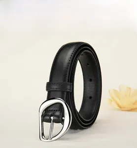 Detail of black leather belt with a silver irregular oval metal pin buckle and stitching