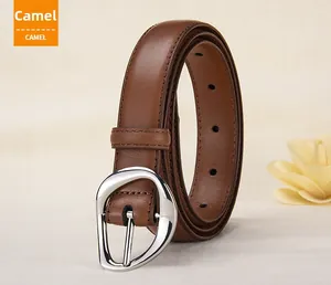 Detail view of camel leather belt featuring a unique irregular silver metal buckle and stitching