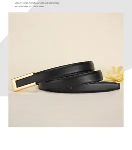 Détail d'une fine ceinture en cuir noir avec boucle rectangulaire dorée et surpiqûres fines