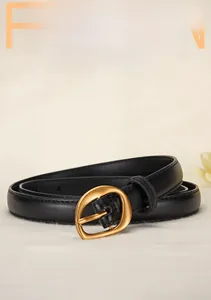 Detail of premium black cowhide leather belt with a vintage gold alloy pin buckle