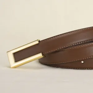 Ceinture pour femme en cuir marron avec boucle rectangulaire dorée sur fond textile beige