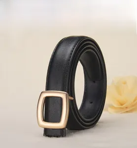 Detail of minimalist black leather belt featuring a matte gold square buckle on white background