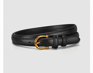 Detail of slim black leather belt featuring a vintage gold horseshoe alloy buckle