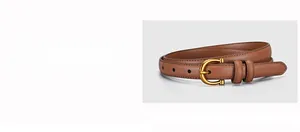 Detail of a thin brown leather belt with a golden horseshoe buckle and fine stitching