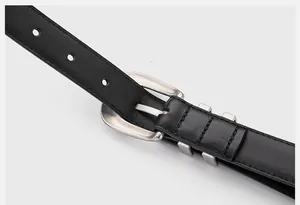 Close-up of black genuine leather belt with a vintage silver metal buckle and fine stitching