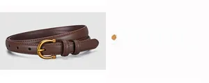 Close-up of slim brown leather belt featuring a matte gold horseshoe-shaped buckle