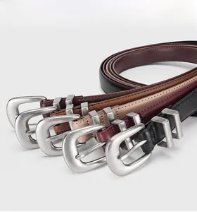 Close-up of multicolored genuine leather belts with vintage matte silver pin buckles