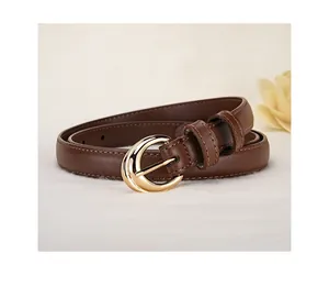 Detailed close-up of brown leather belt with gold crescent buckle and fine stitching