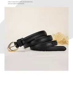 Detail of slim black leather belt featuring a polished gold oval buckle and fine stitching