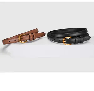 Detail view of black and brown leather thin belts with golden horseshoe buckles