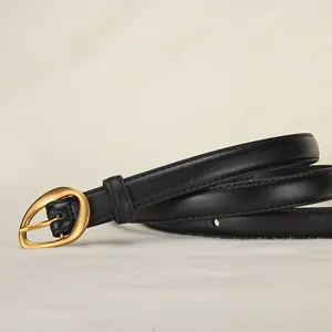 Women's vintage black leather belt with a polished gold oval buckle on a beige textile