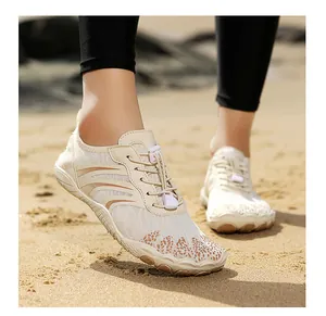 Detail of beige breathable mesh water shoes with quick-lace system on a sandy beach