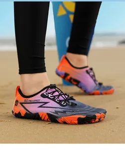 Outdoor-Nahaufnahme von Schnelltrocknende Wasserschuhe auf Sand mit Orange-Rosa-Farbverlauf