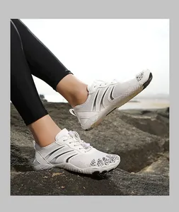 Close-up of breathable mesh water shoe with quick-lace system on seaside rocks