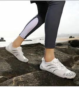 Quick-dry barefoot water shoes with white mesh upper on coastal rocks for outdoor trekking