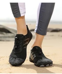 Close-up of quick-dry five-finger water shoes with drawstring lock on a sandy beach