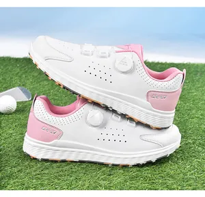 Details von weiß-rosa Golfschuhen mit Drehverschluss auf grünem Rasenuntergrund