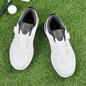 Weiße und graue Golf-Sportschuhe mit Drehverschluss auf grünem Rasenhintergrund