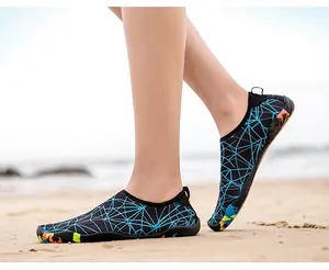 Détail de chaussures aquatiques respirantes sur sable avec motifs bleus et boucle talon