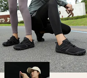 Détail de chaussures pieds nus en maille noire avec laçage rapide et semelle antidérapante