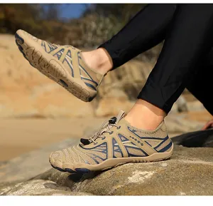 Detail of khaki outdoor water shoes with quick-lace system on rocky beach terrain