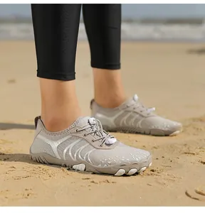 Detail der grauen Barfußschuhe am Strand mit Schnellverschluss und Gummisohle