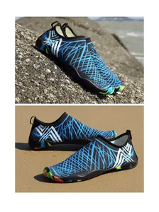 Primer plano de zapatos de agua de secado rápido con malla azul sobre rocas y arena