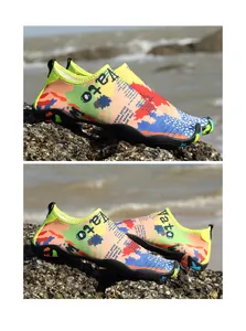 Primer plano de zapatos de agua de secado rápido con patrones de graffiti en playa rocosa
