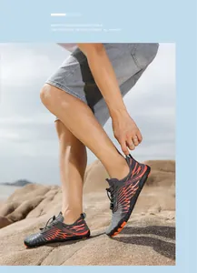 Detail of outdoor water shoes with gray mesh, orange stripes and quick-lace system