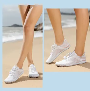 Detail of white beach water shoes with breathable mesh and anti-slip rubber soles on sand