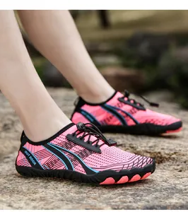 Outdoor water shoes for women on rocks featuring pink mesh upper and anti-slip rubber sole