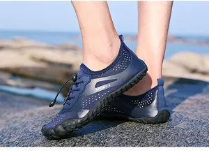 Détail de chaussures aquatiques bleues à séchage rapide avec logo SPORT-X sur rochers