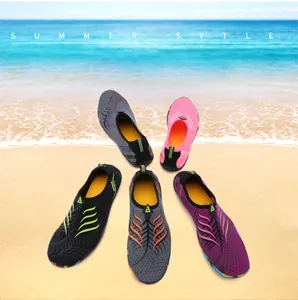 Cinque colori di scarpe da spiaggia antiscivolo disposte a ventaglio su uno sfondo di sabbia