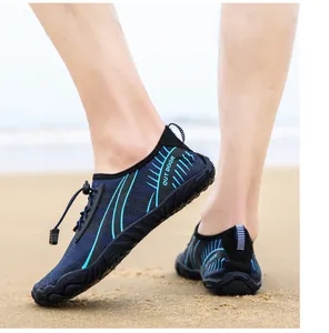 Detail of blue outdoor wading shoes with quick-lace system and mesh on a beach