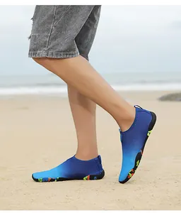 Close-up of quick-dry water shoes with teal gradient design and anti-slip rubber sole on beach
