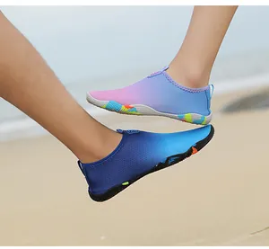 Detail of breathable mesh water shoes with anti-slip rubber soles on a sandy beach