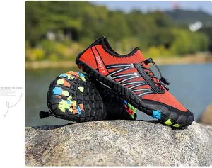 Détail de chaussure aquatique orange avec semelle antidérapante sur rochers extérieurs