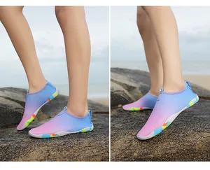 Detail of blue and pink gradient water shoes with non-slip rubber soles on beach rocks